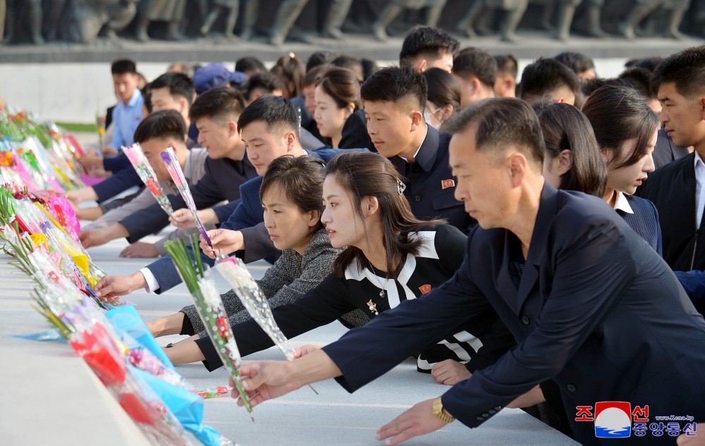 위대한 수령 김일성동지와 위대한 령도자 김정일동지의 동상에 일군들과 근로자들, 인민군장병들과 청소년학생들 꽃바구니 진정