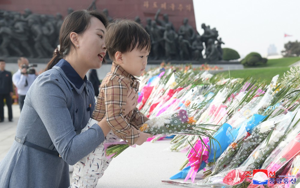 위대한 수령 김일성동지와 위대한 령도자 김정일동지의 동상에 일군들과 근로자들, 인민군장병들과 청소년학생들 꽃바구니 진정